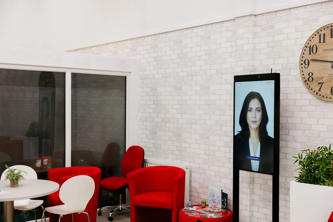 A floor-standing RAVO kiosk in a reception area, showing the assistant ready to help